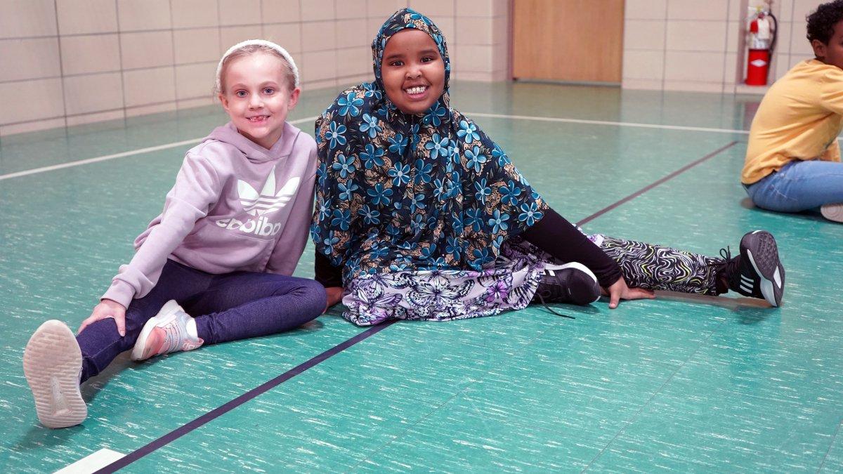 students sitting on gymnasium floor